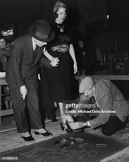 Actress Eleanor Powell has her shoe prints added to cement in front of Grauman's Chinese Theatre with the help of Sid Grauman and Jean W. Klossner in...