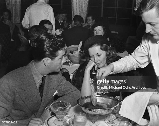 Actor Robert Taylor and his wife actress Barbara Stanwyck have dinner in Los Angeles, California.