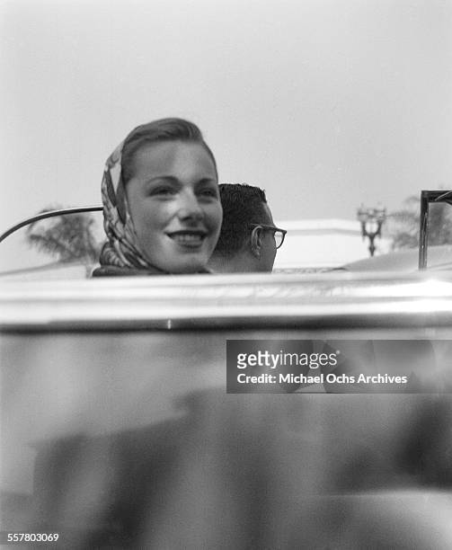 Actress Eleanor Parker smiles as she rides in a convertible car in Los Angeles, California.