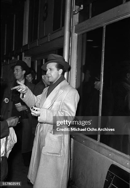 Actor Dick Powell is photographed on a street in Los Angeles, California.