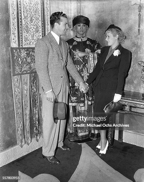 Actor Dick Powell with his wife actress Joan Blondell attend an event at Grauman's Chinese Theatre in Los Angeles, California.