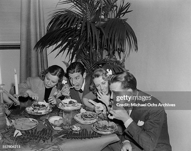 Actor Dick Powell eats with his wife actress Joan Blondell and actress Glenda Farrell and her husband Henry Ross attend an event in Los Angeles,...
