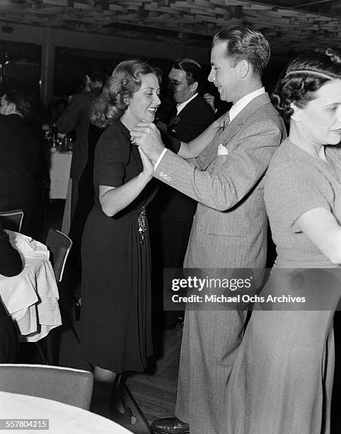 Actor Dick Powell dances with his wife actress Joan Blondell during an event in Los Angeles, California.