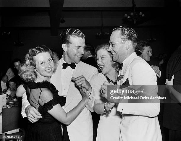 Actor Dick Powell dances with his wife actress Joan Blondell during an event in Los Angeles, California.