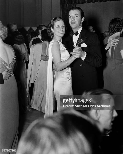Actor Robert Taylor dances with Janet Gaynor at an event in Los Angeles, California.