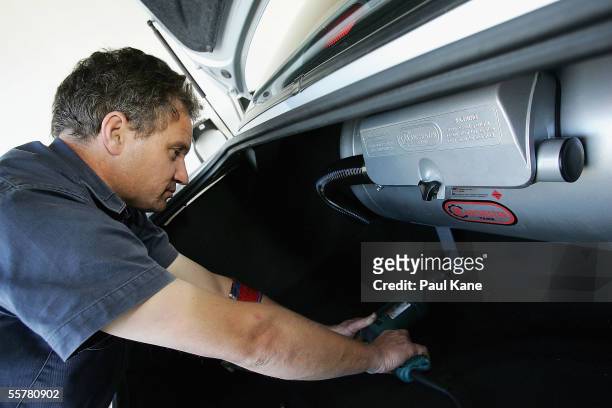 An autogas installer works on converting a petrol car to run on LPG at his workshop September 22, 2005 in Perth, Australia. Thousands of Australian...