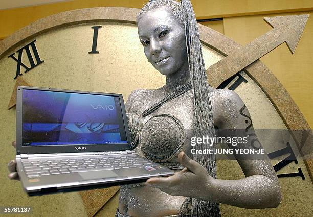 Model with her body painted in silver shows Sony's new notebook computer, VGN-TX16LP, which appeals to consumers with its display cover made of...