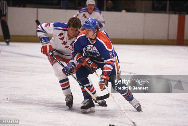 Canadian hockey player Mark Messier of the Edmonton Oilers struggles for position with Barry Beck of the New York Rangers, early 1980s.