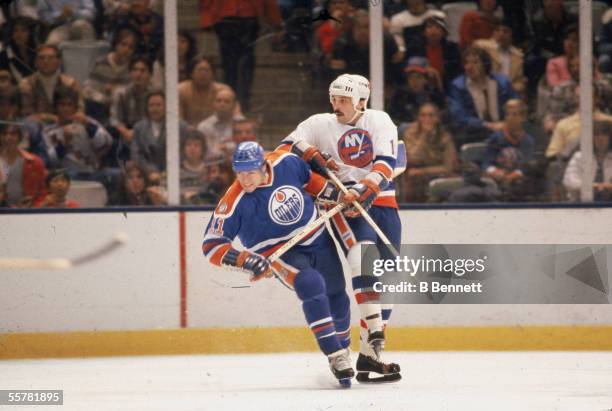 Canadian hockey player Mark Messier of the Edmonton Oilers jostles for position with Bryan Trottier of the New York Islanders during a game in the...