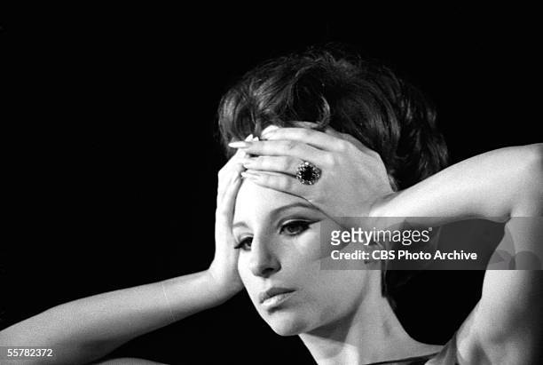 Close-up of American singer and actress Barbra Streisand as she places her hands on her forehead during her live concert in Sheep Meadow, Central...