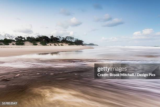 tallows creek running out into the ocean at a spot known as dolphins at tallows beach after heavy storms - brook mitchell stock pictures, royalty-free photos & images