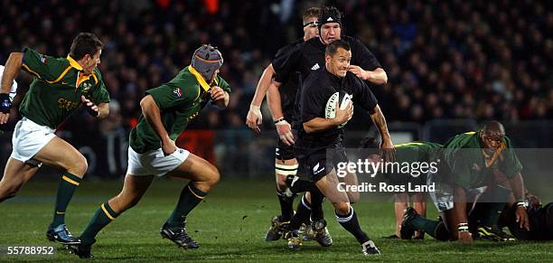 Carlos Spencer runs the ball past Juan Smith and Joost van der Westhuizen , as Lawrence Sephaka and Joe van Neikerk , during the All Blacks 1911 win...