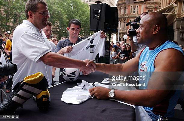 Former All Black jonah Lomu shakes hands with a fan during a public signing session at the Adidas Super store in Sydney as the All Blacks prepare for...