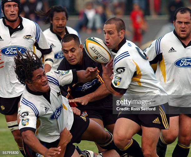 Hurricanes Rodney So'oialo slips the ball to team mate Jason Spice in a tackle by the Chiefs David Briggs in a pre season Super 12 Rugby game at the...