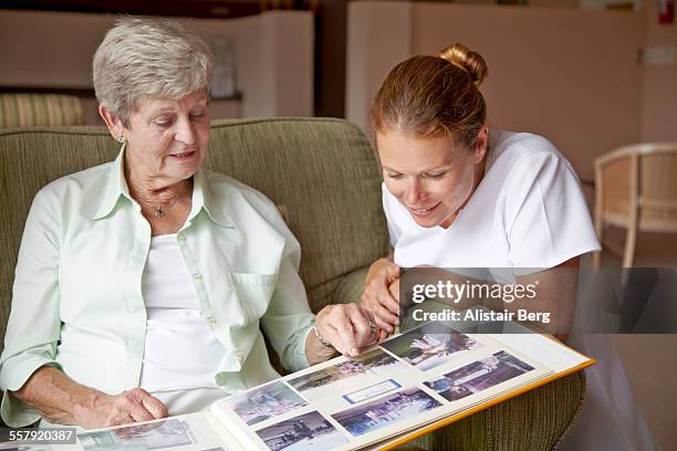 nurse and resident in a retirement home - fotoalbum stock-fotos und bilder