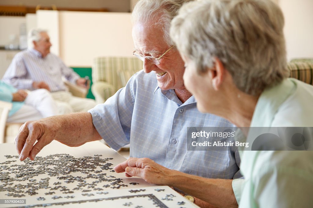 Elderly couple doing jigsaw puzzle