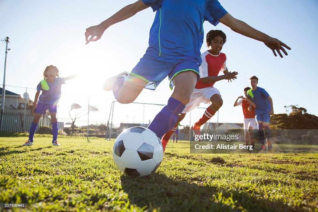 Close up of boy kicking soccer ball