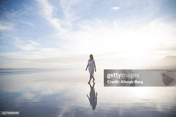 woman walking on beach - innocence fotografías e imágenes de stock