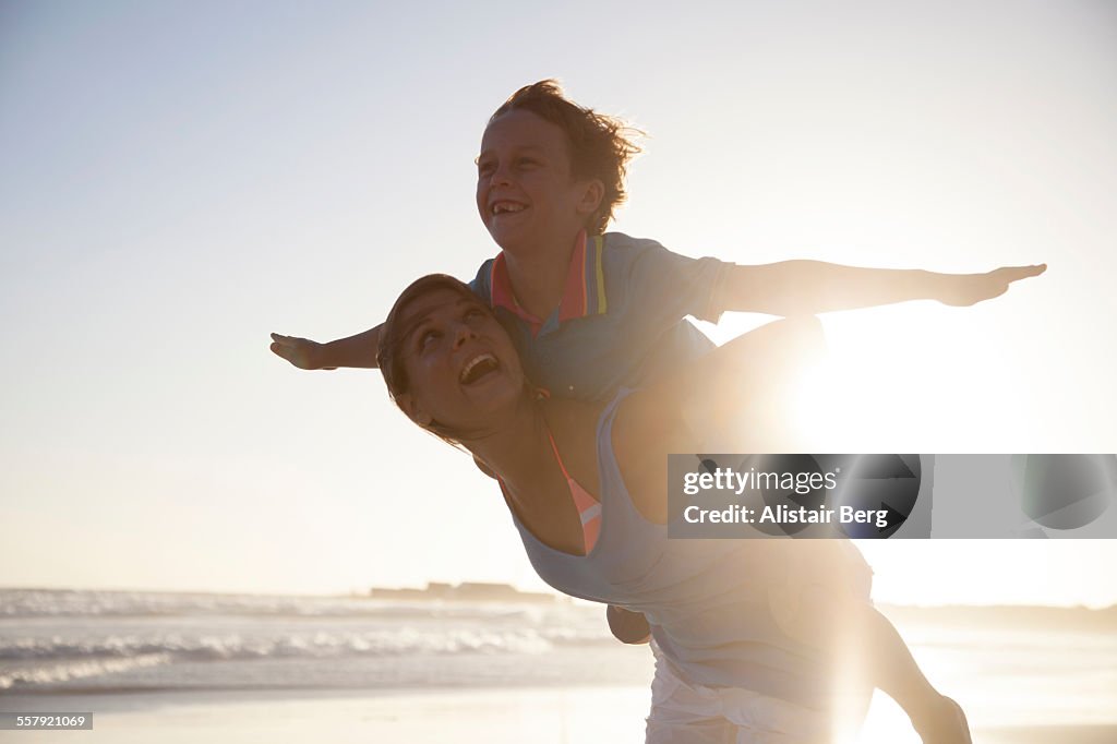 Woman carying boy on beach