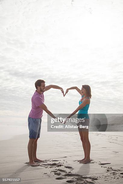 couple making heart together on beach - footprint heart shape stock pictures, royalty-free photos & images