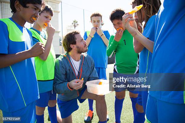 boys soccer team resting during a game - nutrition coach stock pictures, royalty-free photos & images