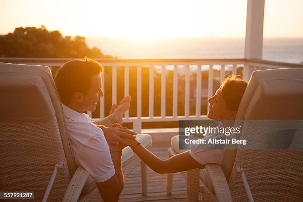 couple holding hands at sunset - achterover leunen stockfoto's en -beelden