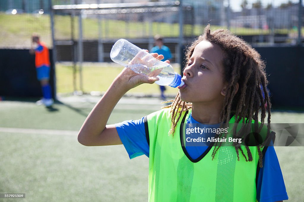 Boy drinking water at soccer training