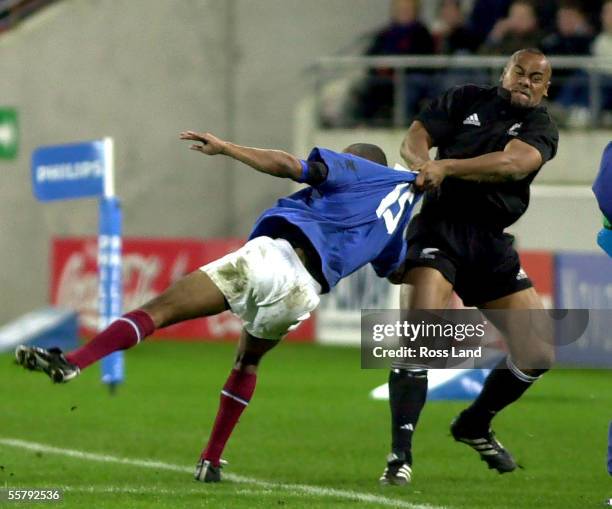 Jonah Lomu removes French fullback Pepido Elhorga from the field of play, during the All Blacks 3712 win over France in the rugby test at...