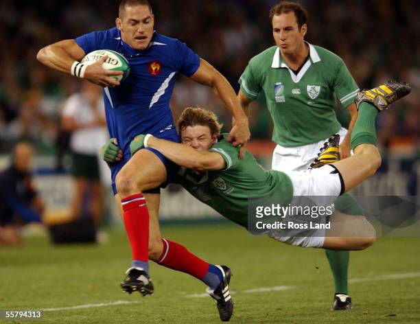 Kiwi born French player Tony Marsh is dragged down in a tackle by By Brian O'Driscoll, during the France V ireland quarter final Rugby World Cup 2003...
