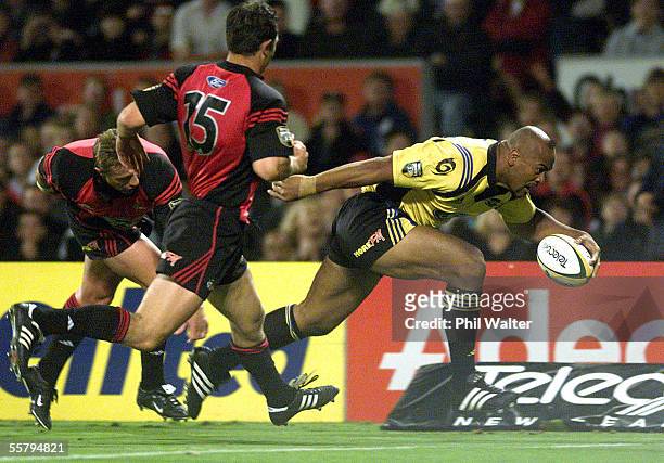 Hurricanes Jonah Lomu runs in to score his try despite the tackle of Crusaders Justin Marshall in their Super 12 rugby match played at Jade Stadium,...
