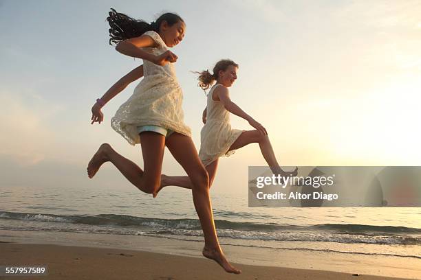 two girls jumping on the beach - 飛行機のまね ストックフォトと画像