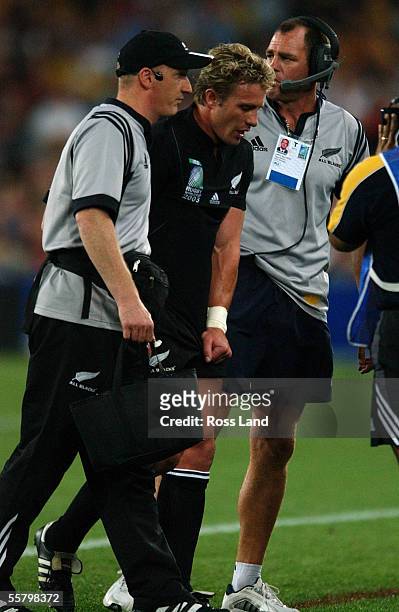An injured Justin Marshall is helped from the field by All Black Physiotherapist Steve Muir and Daryl Halligan during the All Blacks 1022 loss to the...