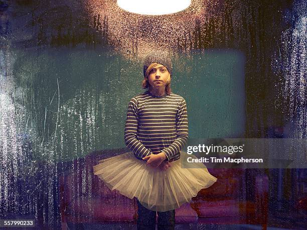 boy wearing tutu stands by window - saia de bailarina imagens e fotografias de stock