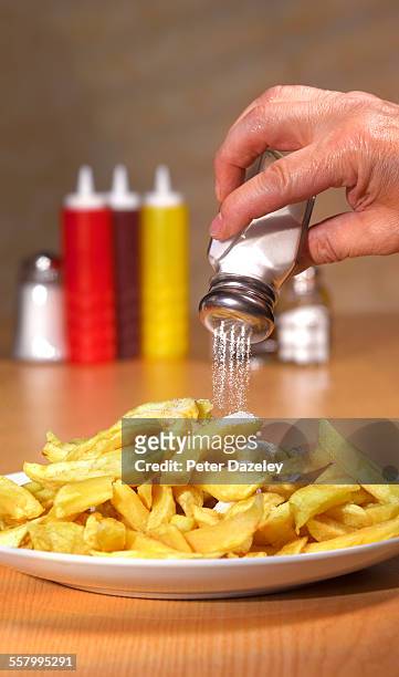 too much salt on chips in cafe - sprinkling salt stock pictures, royalty-free photos & images