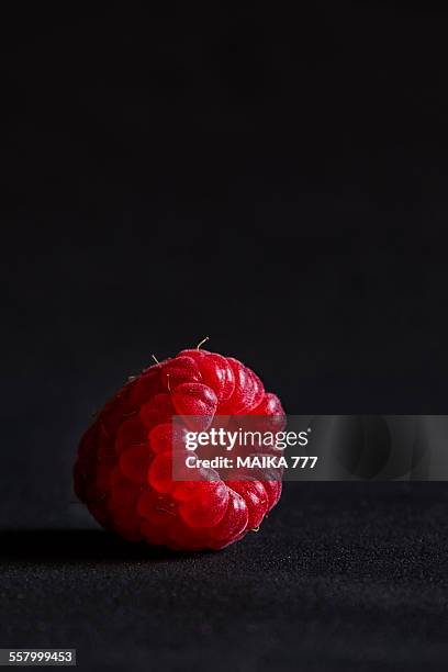 raspberry against black background, close-up - juicy raspberry stock pictures, royalty-free photos & images