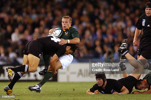 Richie McCaw crashes over Corne Krige as Jorrie Muller is driven back in a tackle by Doug Howlett, during the All Blacks 299 win over South Africa in...