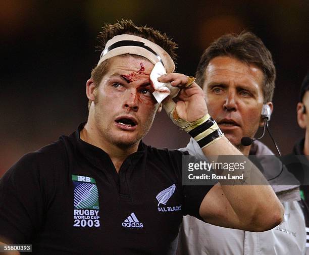 Richie McCaw is escorted from the field for to the blood bin for the second time by team Dr John Mayhew, during his last game for the Springboks...