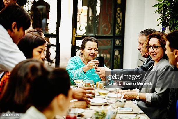 grandfather showing grandmother smartphone - family reunion stock pictures, royalty-free photos & images