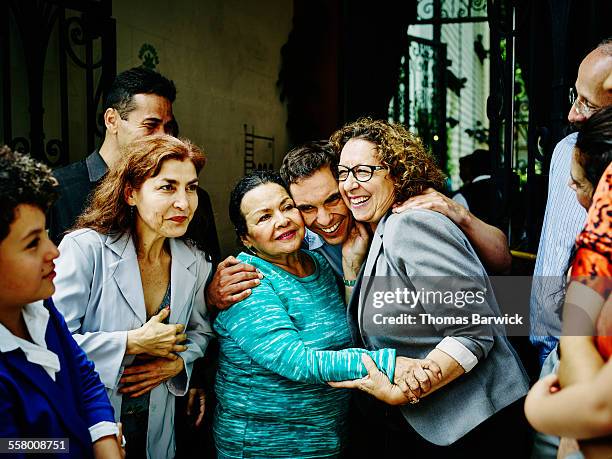man embracing mother and sister during party - family reunion stock pictures, royalty-free photos & images