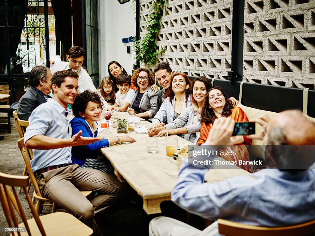 Man taking family portrait in restaurant