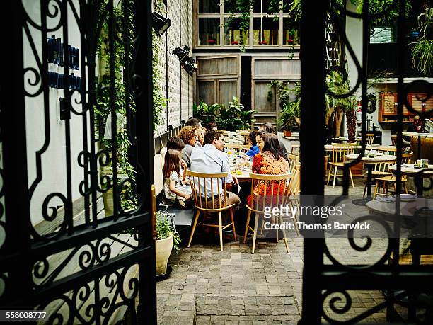 multi-generational family dining in restaurant - courtyard stock-fotos und bilder