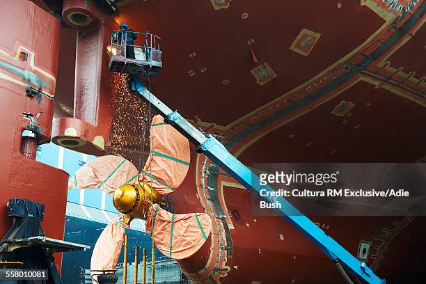 worker working on ship at shipyard, goseong-gun, south korea - scheepsbouwer stockfoto's en -beelden