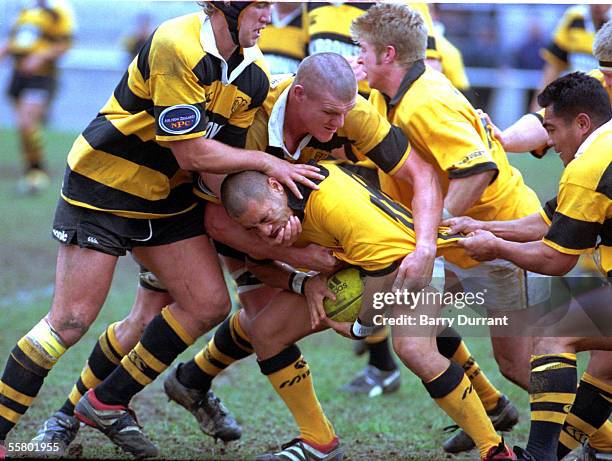 Tanner Vili gets some attention from Taranaki 's Scott Breman , Keith Robinson and Tenning Tyrell , during the NPC warm up match played at Porirua...