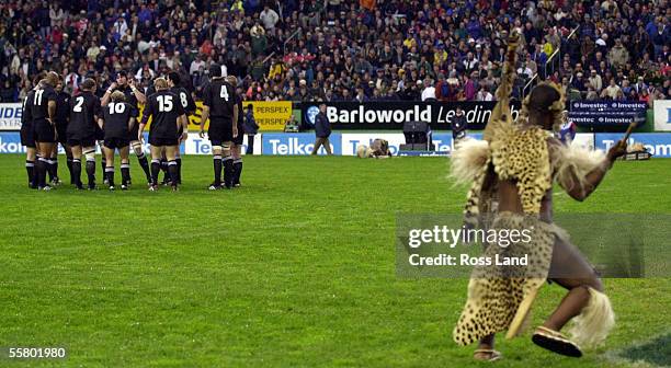 The All Black huddle on the field as they are challenged by a Zulu warrior, prior to their 123 win over the Springboks in the first TriNations rugby...