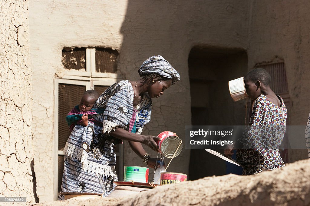 Women with child by the Great Mosque, Djenne, Mali