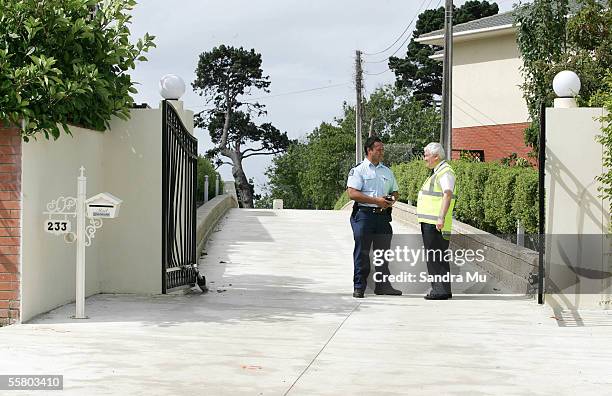 Police Officer talks to the security guard manning the entrance to the property in Howick, Auckland, Monday 7th March, 2005 where 42 year old Qing...