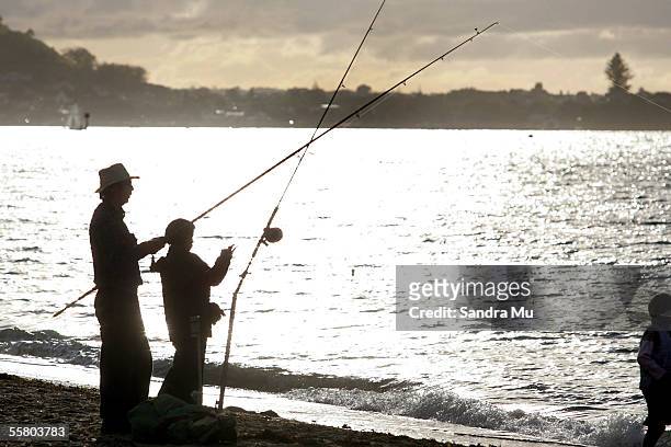 Father and son enjoy the afternoon sun and a spot of fishing at Mission Bay in Auckland, Sunday, June 19, 2005.