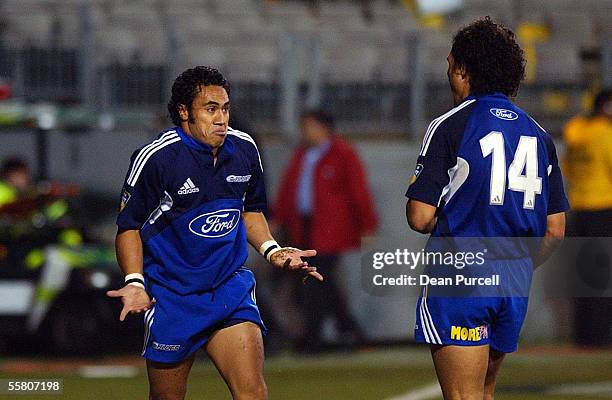 Blues player Orene Ai'i shrugs to his team mate Doug Howlett after he scored a try during the Super 12 Rugby match between the Blues and the Cats...