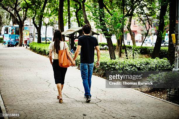couple holding hands walking on pathway - mexico city park stock pictures, royalty-free photos & images