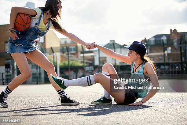 young woman helps friend at basketball court - michael sit stock pictures, royalty-free photos & images